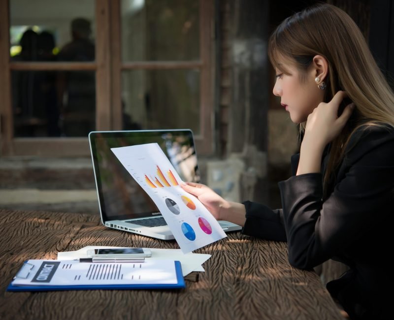 business woman working with documents graphs ,analyzing investment chart working in office.